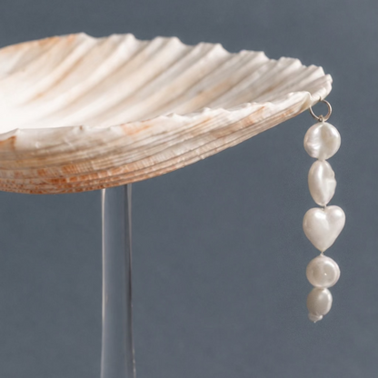 Close-up of pearl bead charm on scallop shell coupe