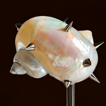 Close-up of spiked pearl shell coupe with metal spikes on glass stem